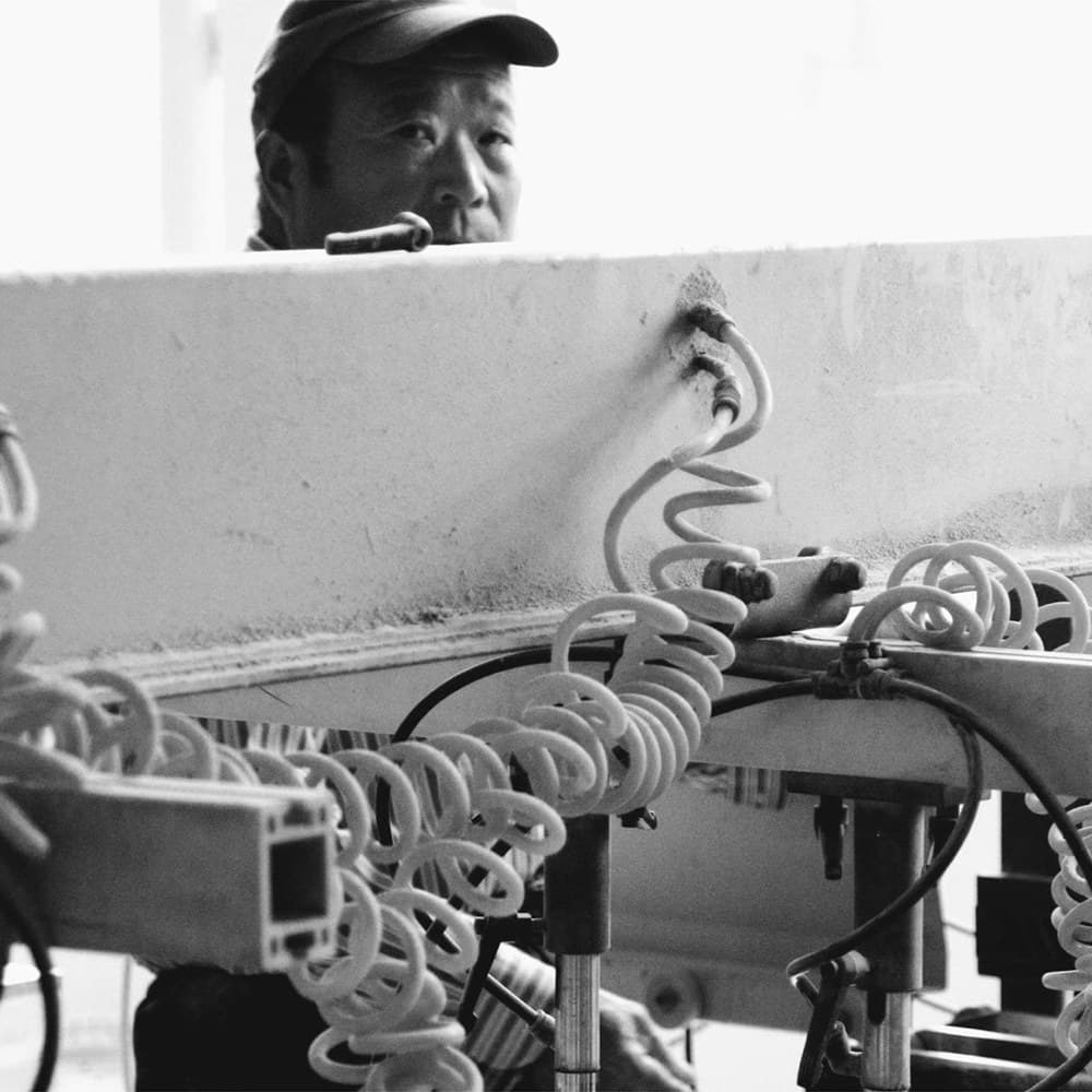 Worker operating an automatic multi-row boring machine