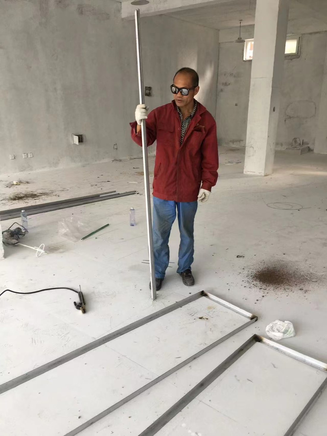 Evan's father in a red work jacket, rebuilding the MJK furniture workshop after the snow